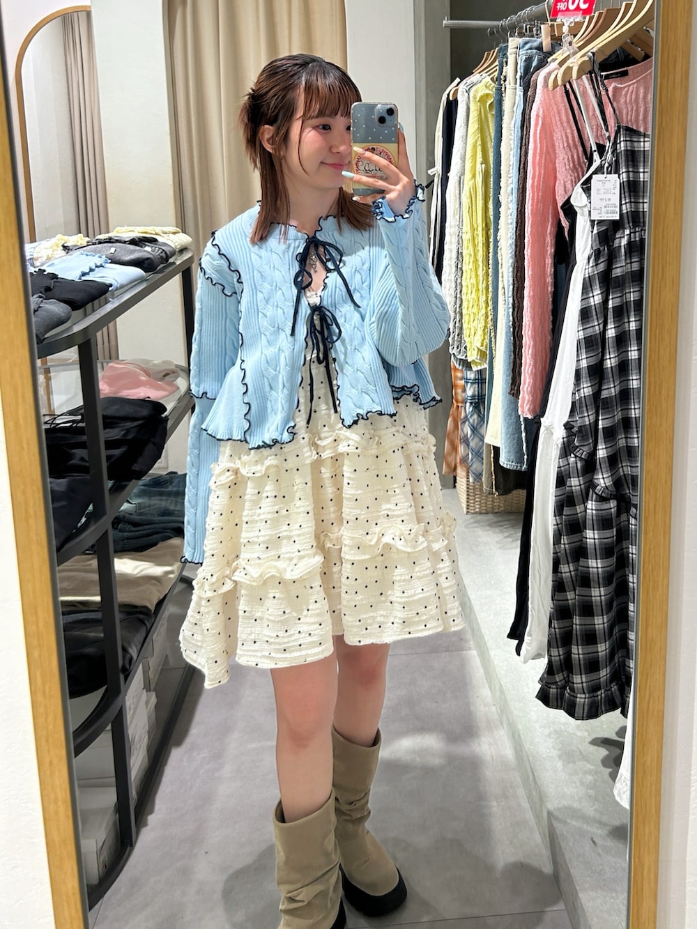 ブルー系のカーディガン/ボレロ、ホワイト系のワンピース、ベージュ系のブーツを着用したレディースの春コーディネートの2枚目の写真