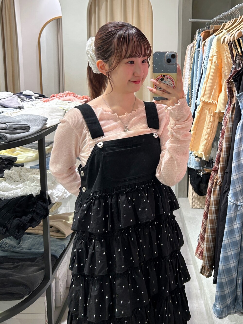 ブラック系のジャンパースカート、ピンク系のTシャツ/カットソーを着用したレディースの春コーディネートの3枚目の写真