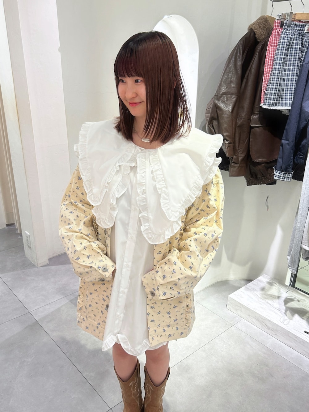 ホワイト系のワンピース、イエロー系のブルゾンを着用したレディースの春コーディネートの2枚目の写真