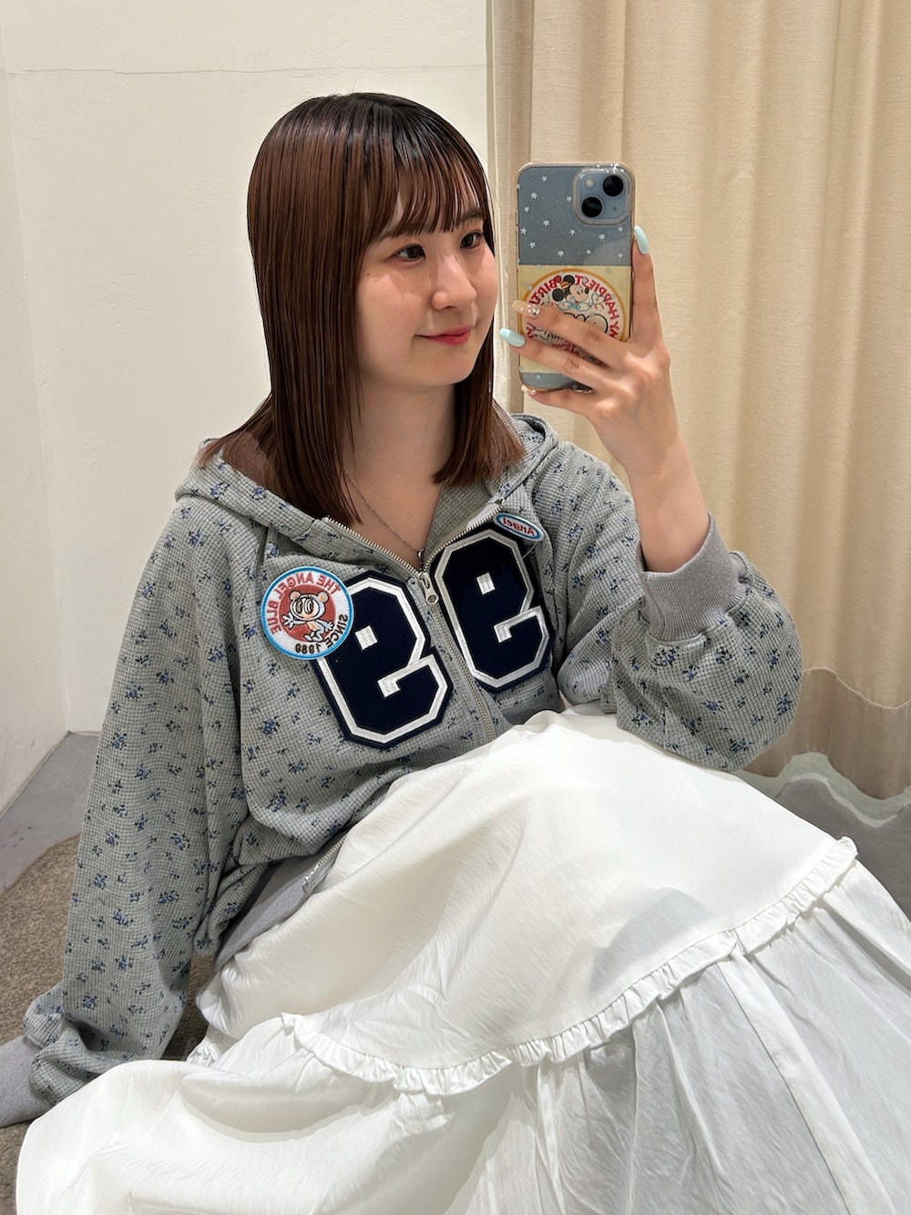 グレー系のパーカー、ホワイト系のワンピースを着用したレディースの春コーディネートの3枚目の写真