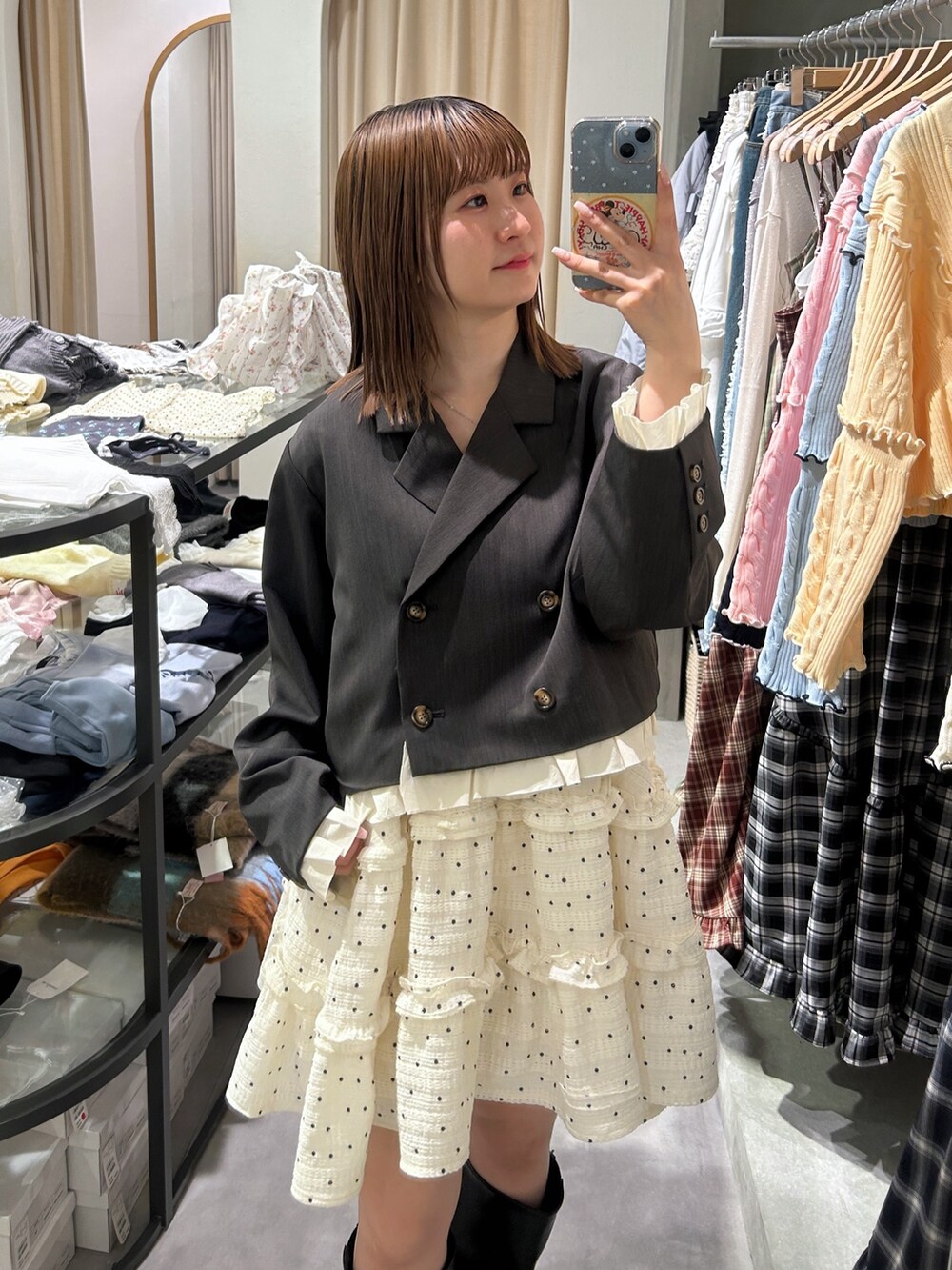 グレー系のテーラードジャケット、ブラック系のトートバッグ、ホワイト系のワンピースを着用したレディースの春コーディネートの3枚目の写真