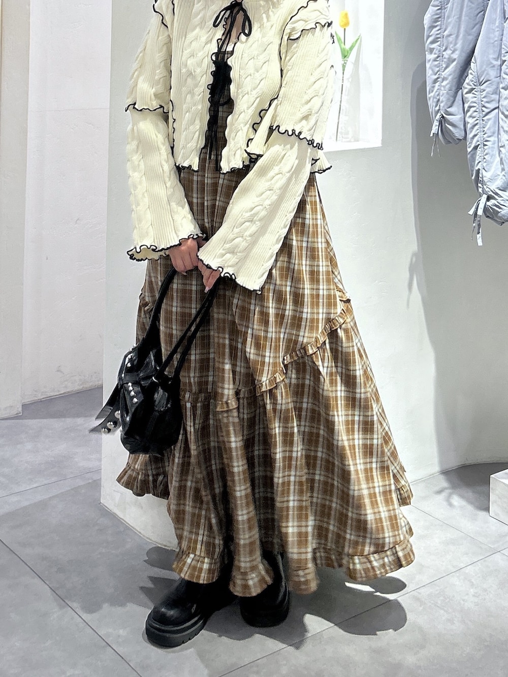 ホワイト系のカーディガン/ボレロ、ブラウン系のワンピース、ブラック系のトートバッグを着用したレディースの春コーディネートの5枚目の写真