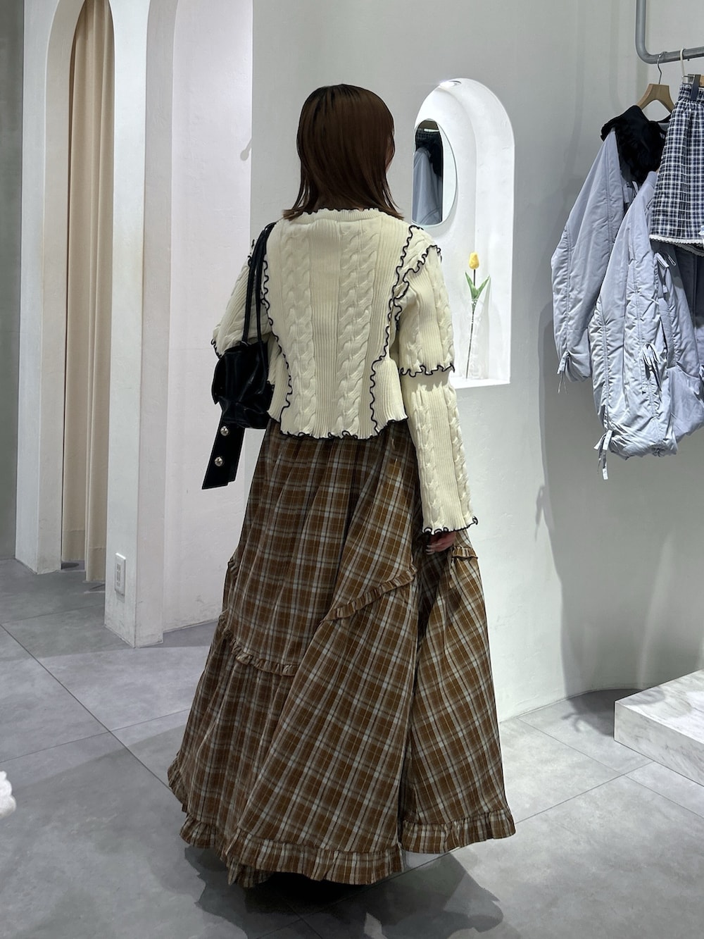 ホワイト系のカーディガン/ボレロ、ブラウン系のワンピース、ブラック系のトートバッグを着用したレディースの春コーディネートの4枚目の写真