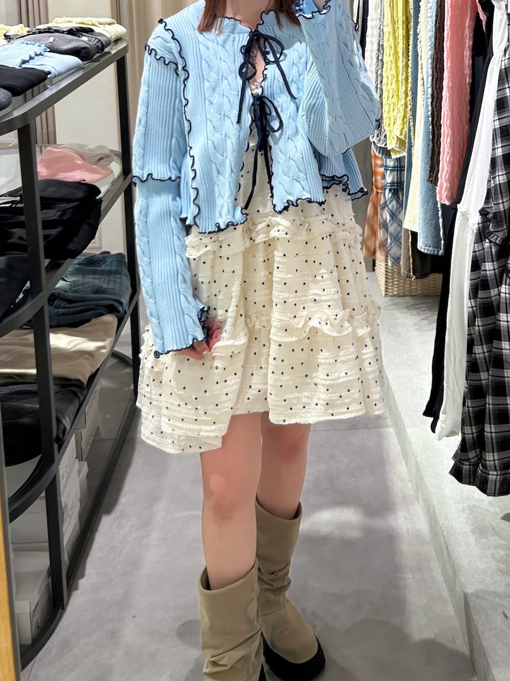 ブルー系のカーディガン/ボレロ、ホワイト系のワンピース、ベージュ系のブーツを着用したレディースの春コーディネートの5枚目の写真