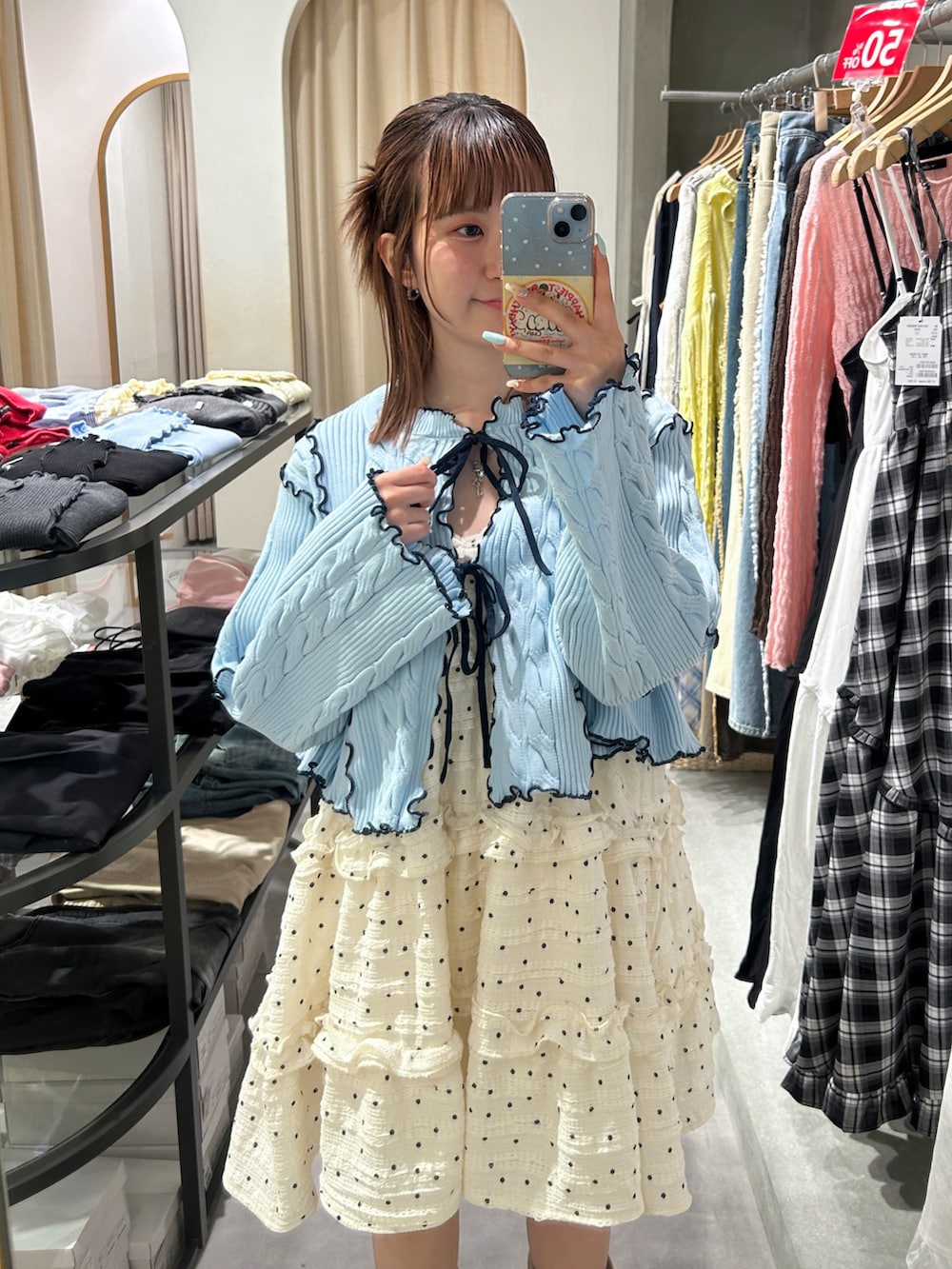 ブルー系のカーディガン/ボレロ、ホワイト系のワンピース、ベージュ系のブーツを着用したレディースの春コーディネートの3枚目の写真