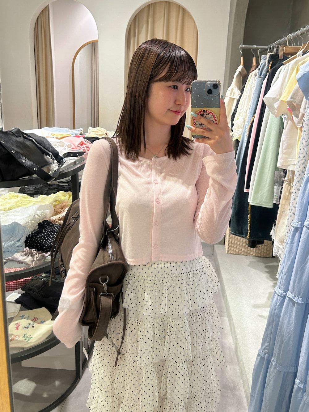 ピンク系のTシャツ/カットソー、ブラウン系のボストンバッグ、ホワイト系のスカートを着用したレディースの夏コーディネートの4枚目の写真