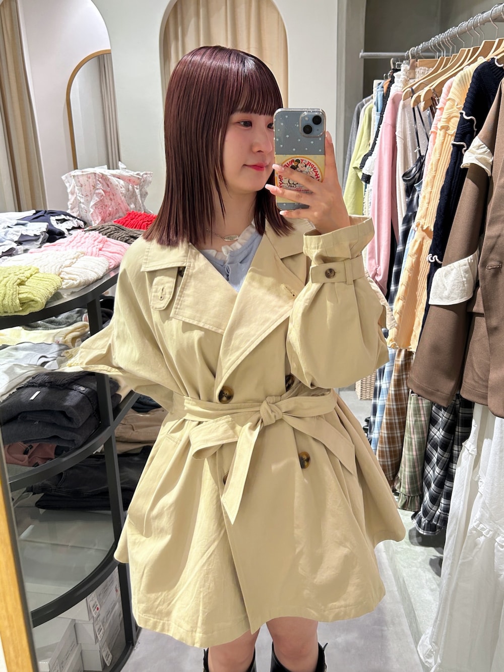 ベージュ系のトレンチコート、ブルー系のカーディガン/ボレロ、ホワイト系のその他パンツを着用したレディースの春コーディネートの4枚目の写真