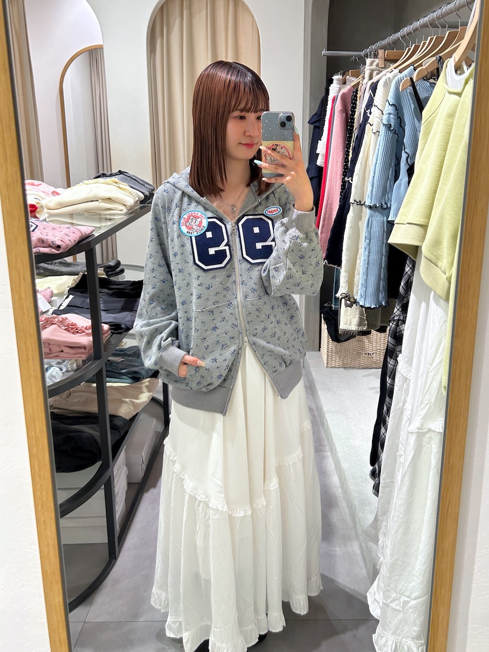 グレー系のパーカー、ホワイト系のワンピースを着用したレディースの春コーディネートの2枚目の写真