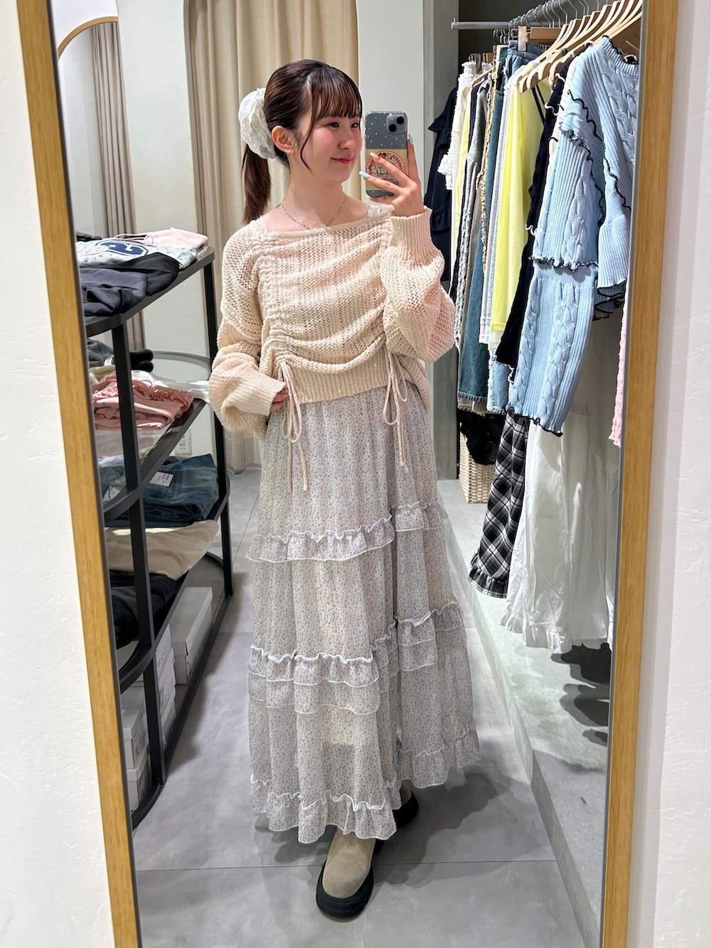 ピンク系のニット/セーター、オレンジ系のワンピース、ベージュ系のブーツを着用したレディースの春コーディネートの2枚目の写真