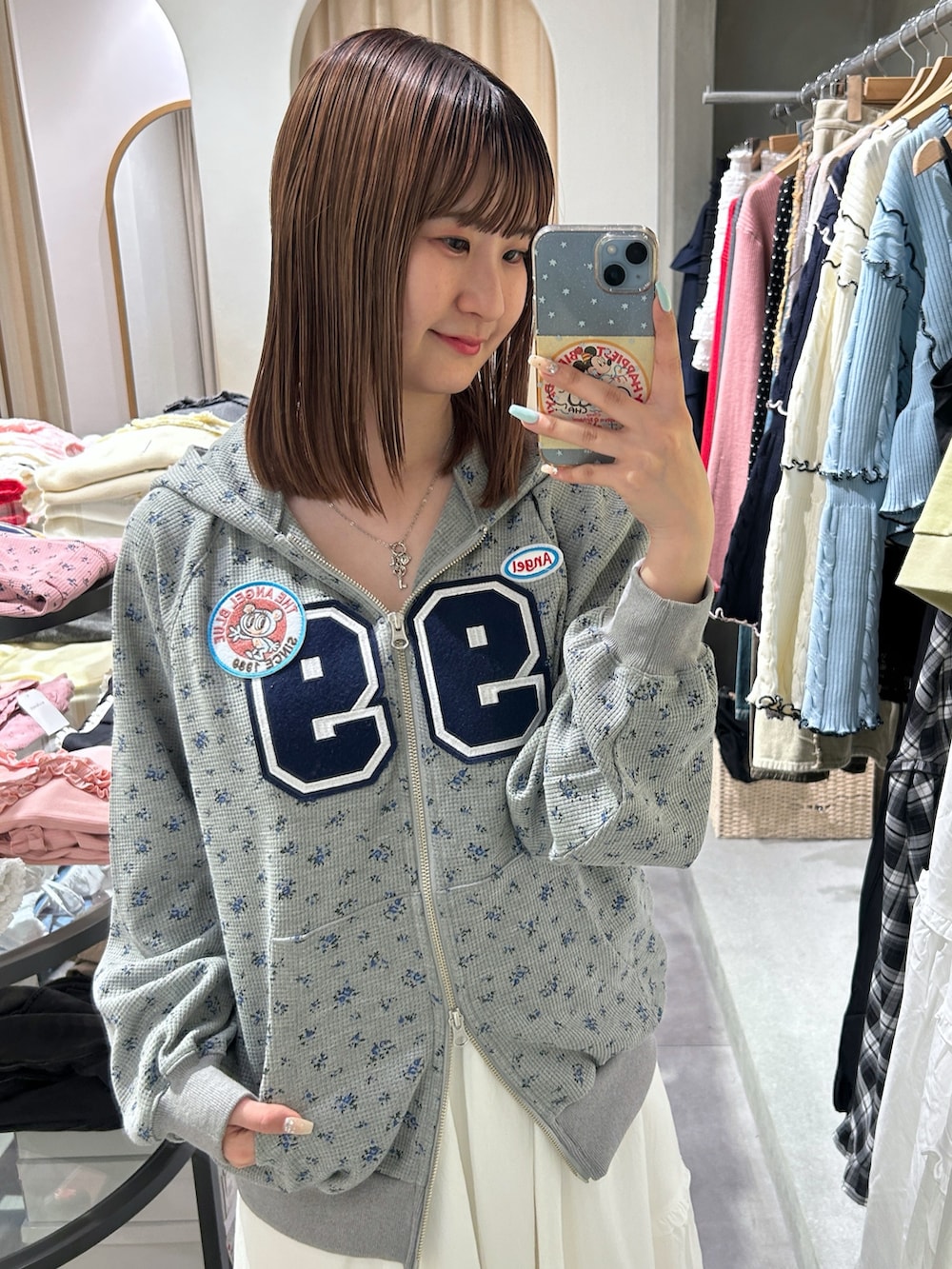 グレー系のパーカー、ホワイト系のワンピースを着用したレディースの春コーディネートの4枚目の写真