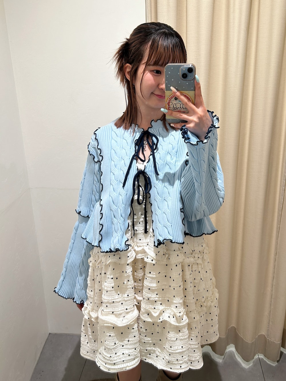 ブルー系のカーディガン/ボレロ、ホワイト系のワンピース、ベージュ系のブーツを着用したレディースの春コーディネートの4枚目の写真