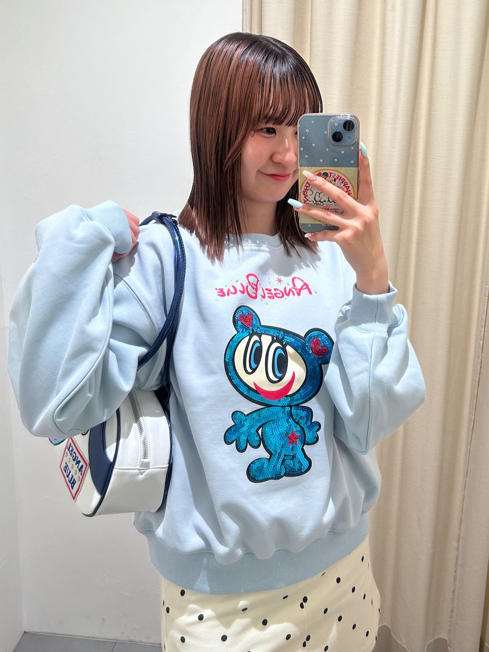 ブルー系のTシャツ/カットソー、ブルー系のボストンバッグ、ホワイト系のスカートを着用したレディースの春コーディネートの3枚目の写真