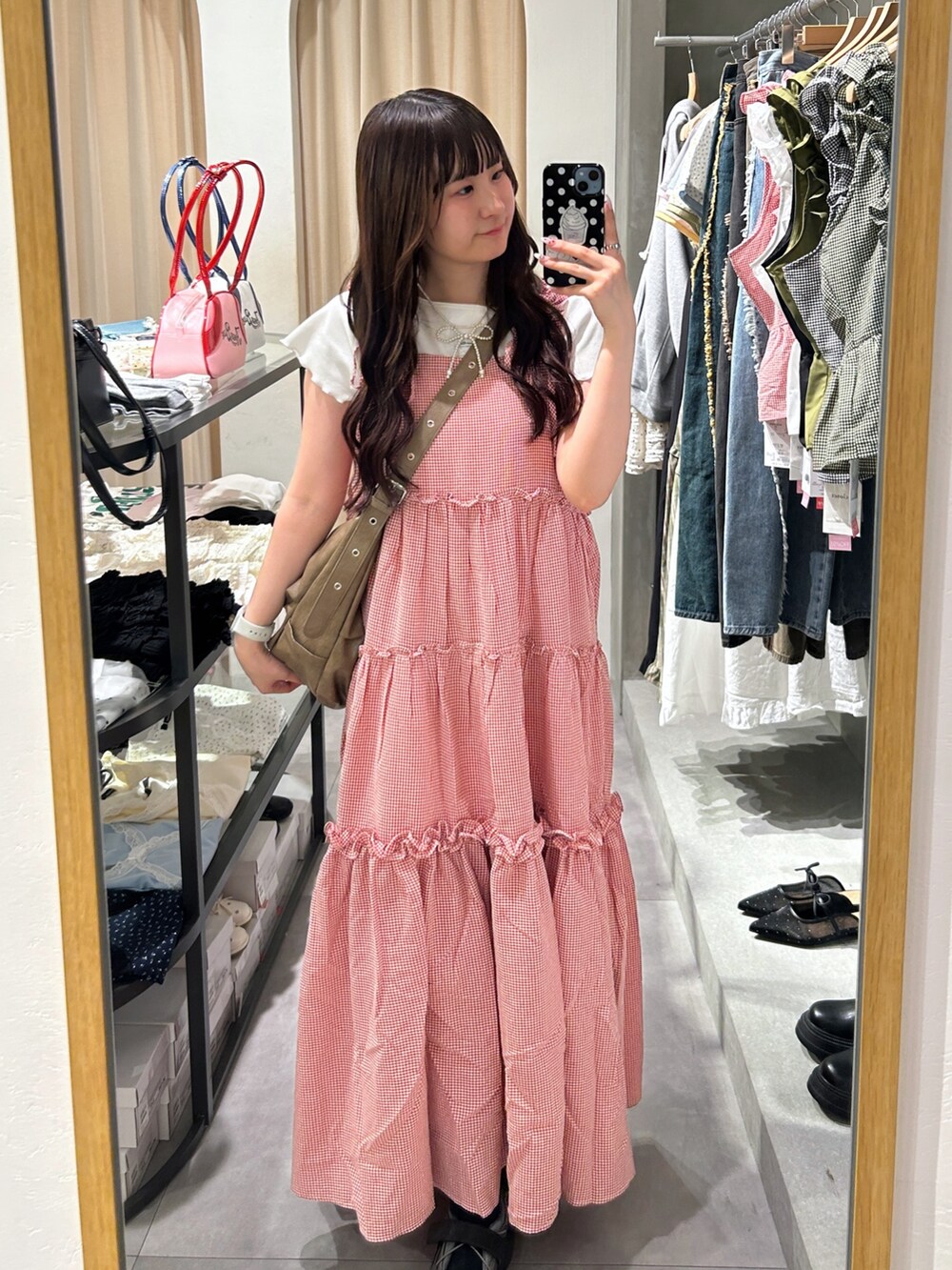 ブラウン系のトートバッグ、レッド系のワンピース、ホワイト系のTシャツ/カットソーを着用したレディースの夏コーディネートの2枚目の写真
