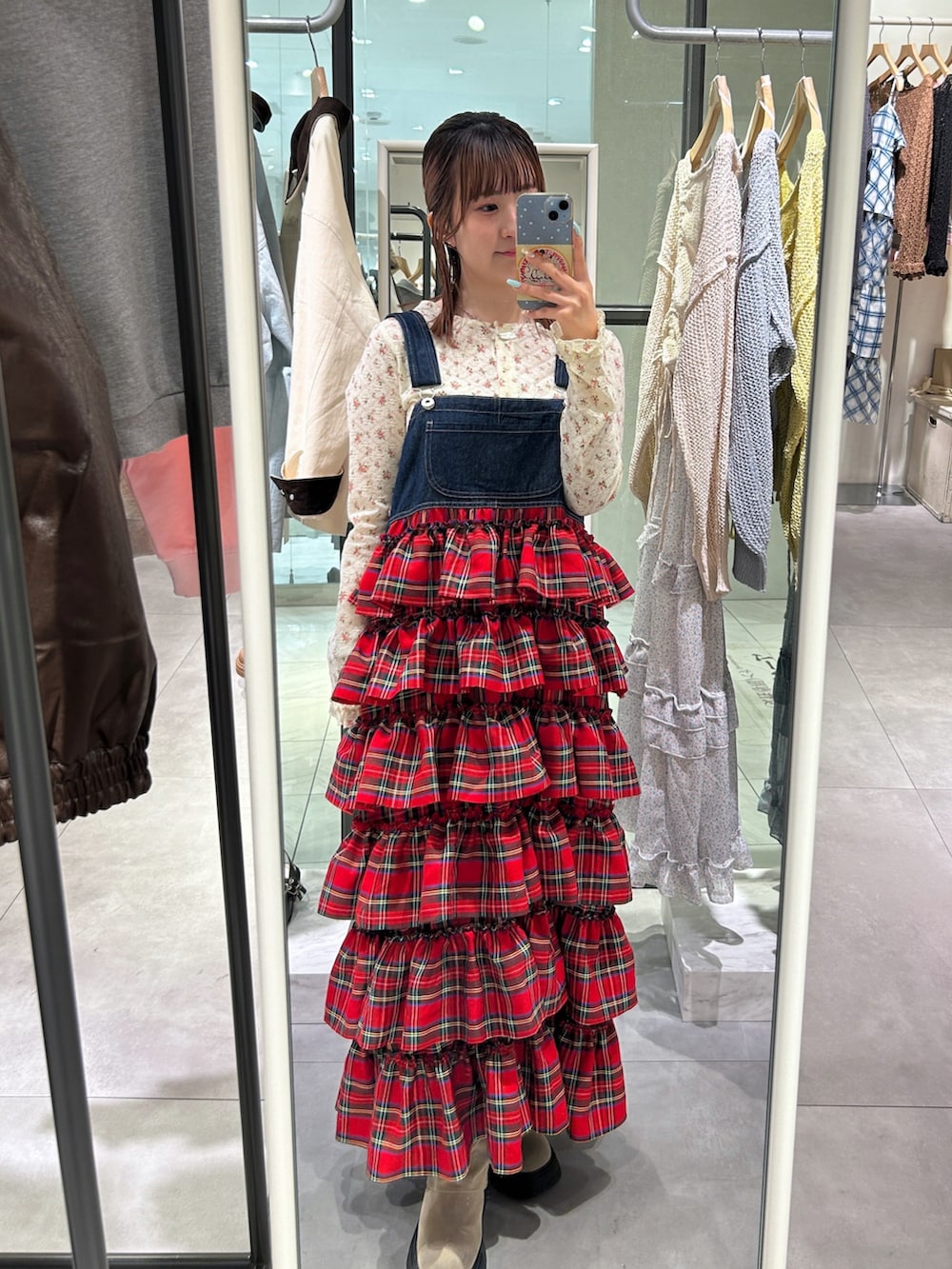 ホワイト系のTシャツ/カットソー、レッド系のジャンパースカート、ベージュ系のブーツを着用したレディースの春コーディネートの2枚目の写真