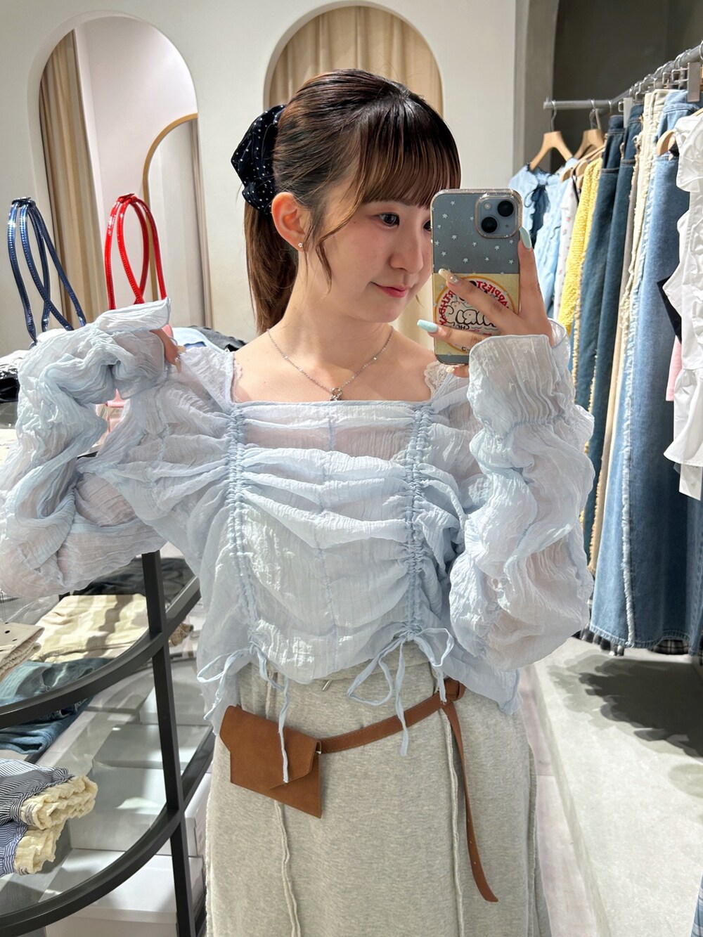 ブルー系のシャツ/ブラウス、ホワイト系のスカート、ブラウン系のベルトを着用したレディースの春コーディネートの2枚目の写真