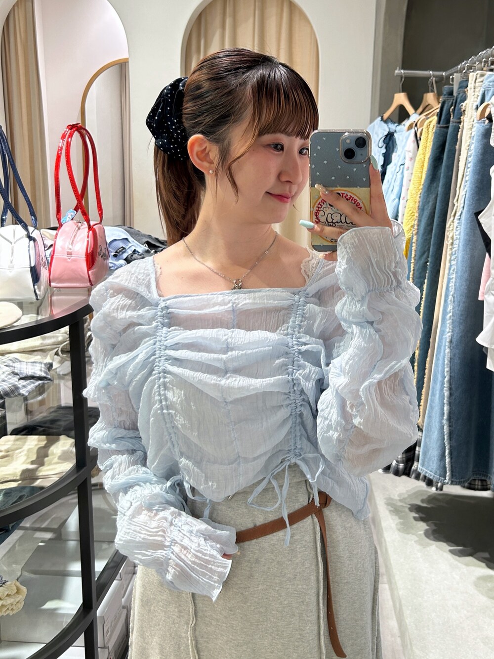 ブルー系のシャツ/ブラウス、ホワイト系のスカート、ブラウン系のベルトを着用したレディースの春コーディネートの4枚目の写真