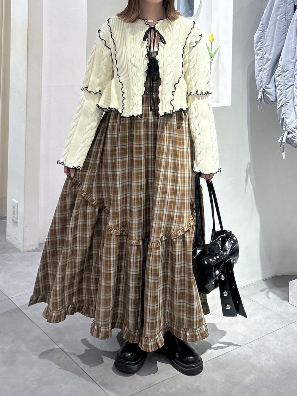 ホワイト系のカーディガン/ボレロ、ブラウン系のワンピース、ブラック系のトートバッグを着用したレディースの春コーディネートの2枚目の写真