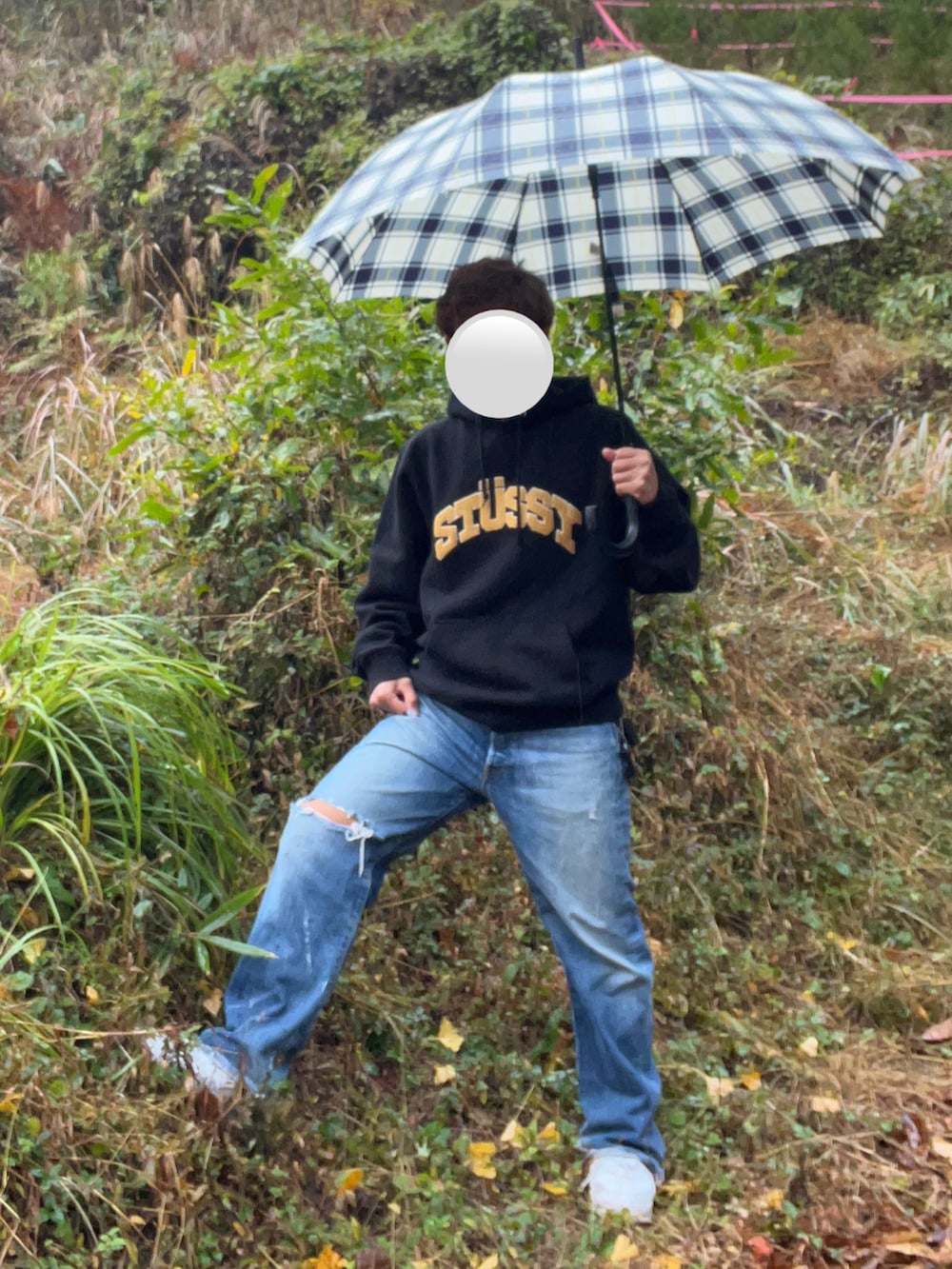 ホワイト系のスニーカー、ブラック系のパーカー、ブルー系のデニムパンツを着用したメンズの秋コーディネートの2枚目の写真