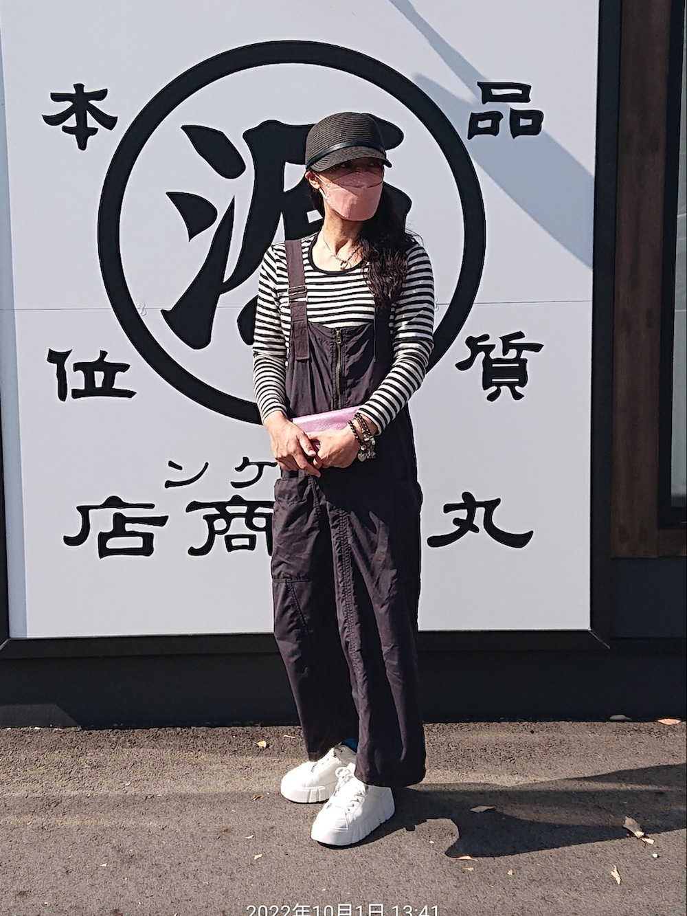 ホワイト系のTシャツ/カットソー、ブラック系のサロペット/オーバーオール、ホワイト系のスニーカーを着用したレディースの秋コーディネートの3枚目の写真