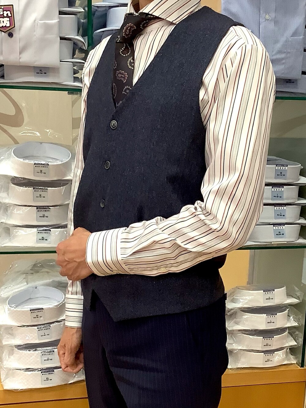 ブルー系のベスト、グレー系のビジネスシャツを着用したメンズの秋コーディネートの2枚目の写真