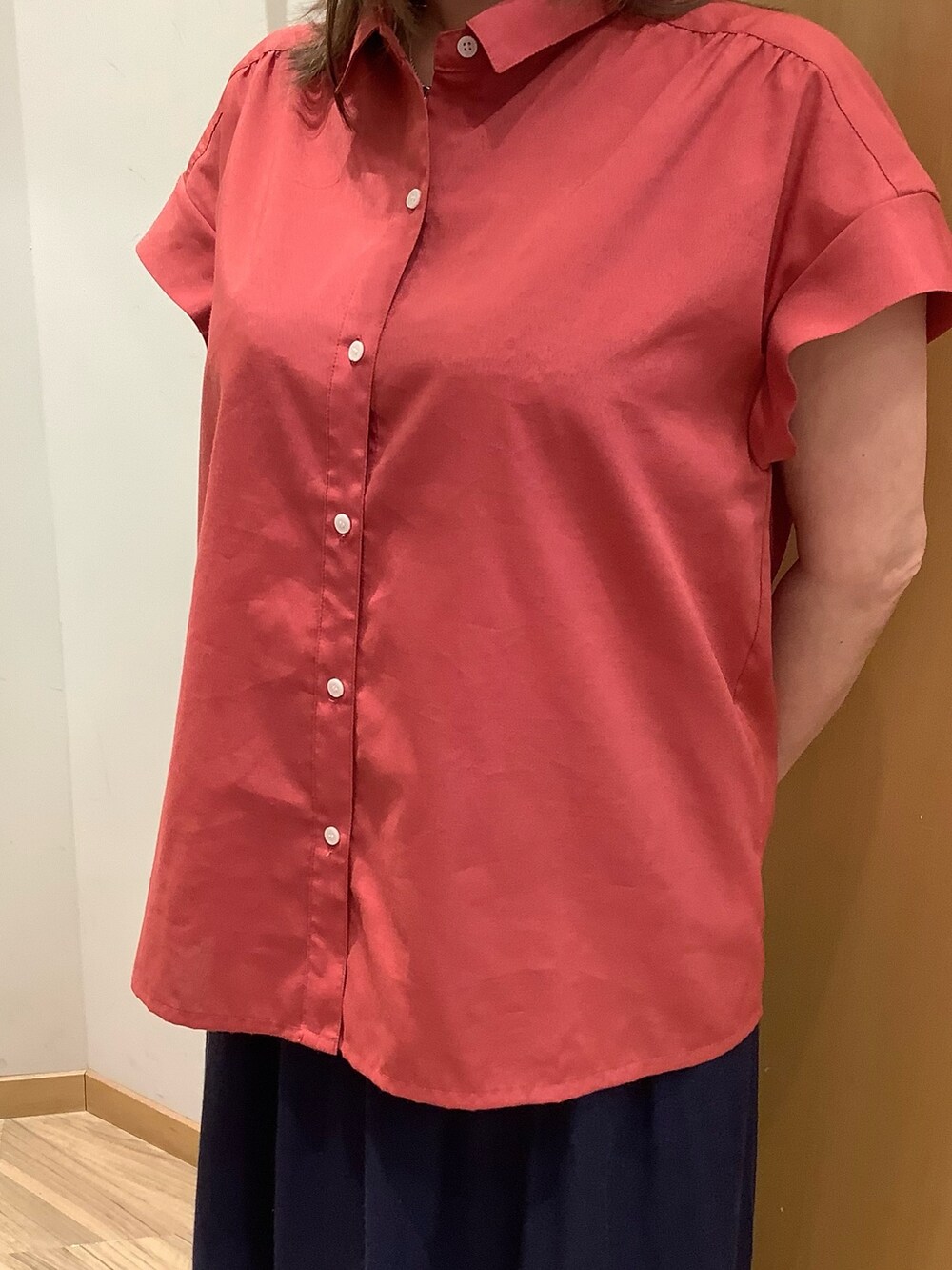 オレンジ系のシャツ/ブラウスを着用したレディースの夏コーディネートの2枚目の写真