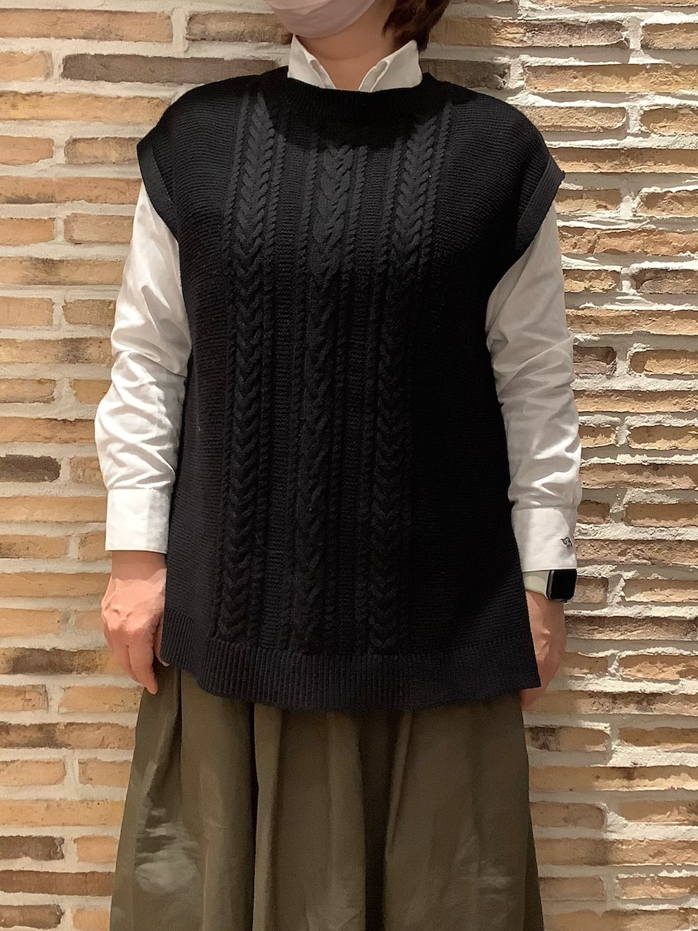 ブラック系のベストを着用したレディースの春コーディネートの2枚目の写真