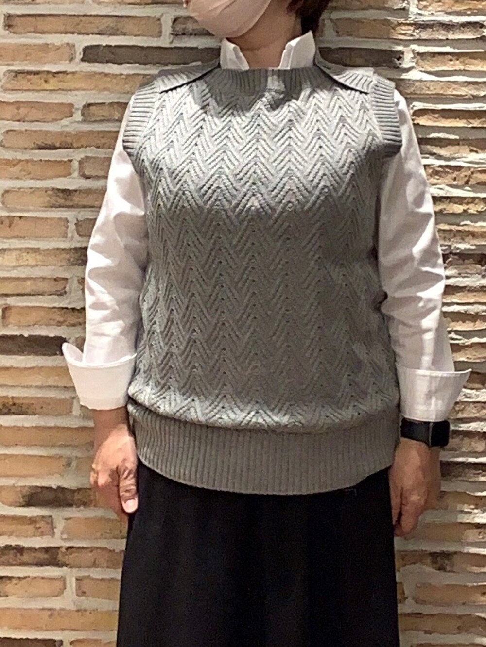 グレー系のベストを着用したレディースの秋コーディネートの2枚目の写真