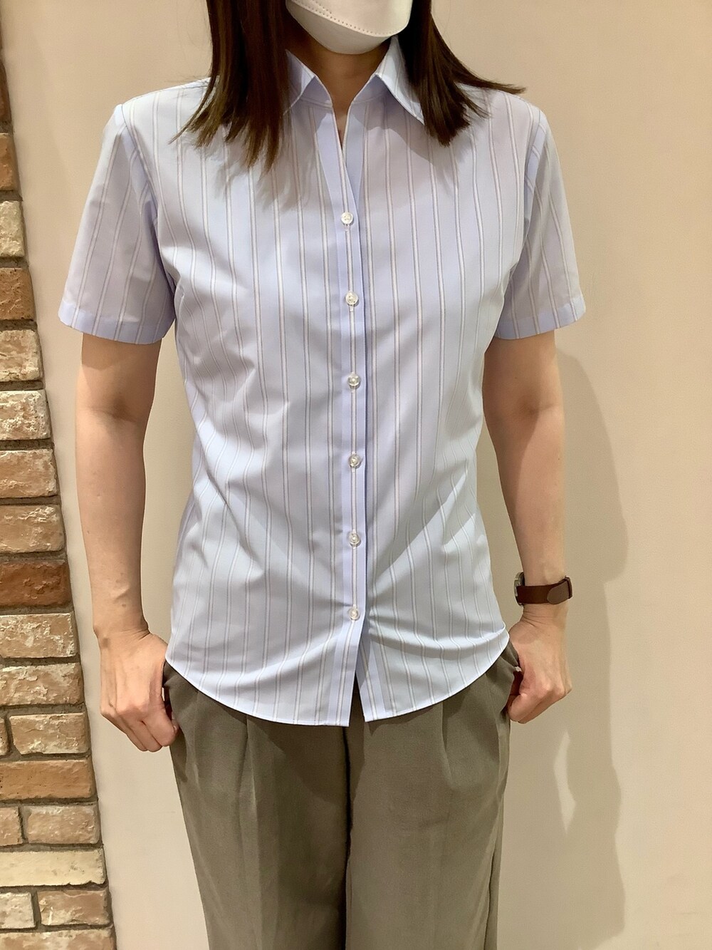 ブルー系のビジネスシャツを着用したレディースの夏コーディネートの2枚目の写真