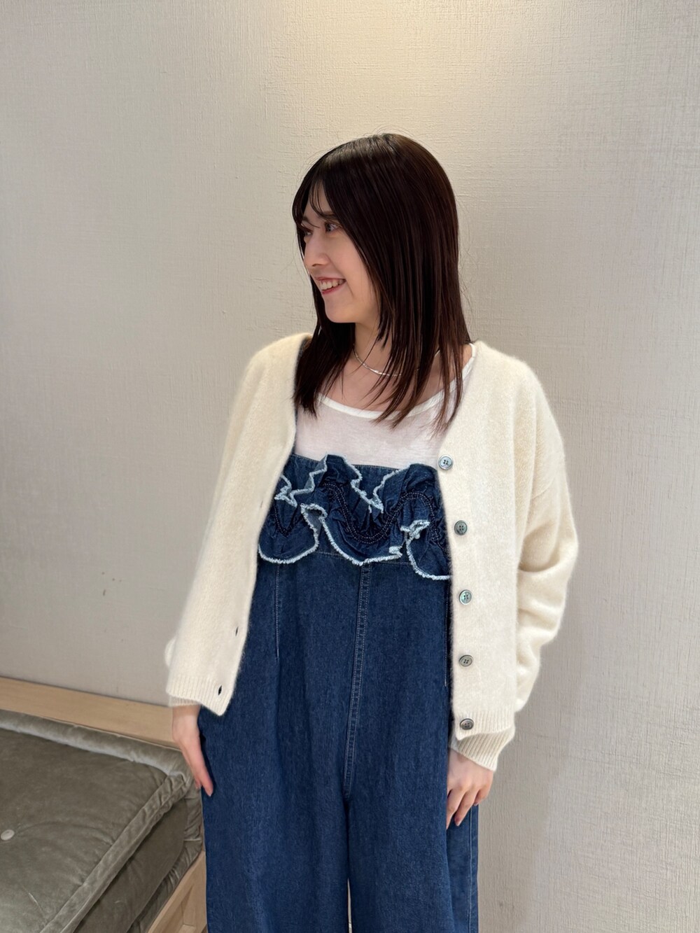 ホワイト系のカーディガン/ボレロ、ブルー系のサロペット/オーバーオール、ブラウン系のパンプスを着用したレディースの秋コーディネートの5枚目の写真