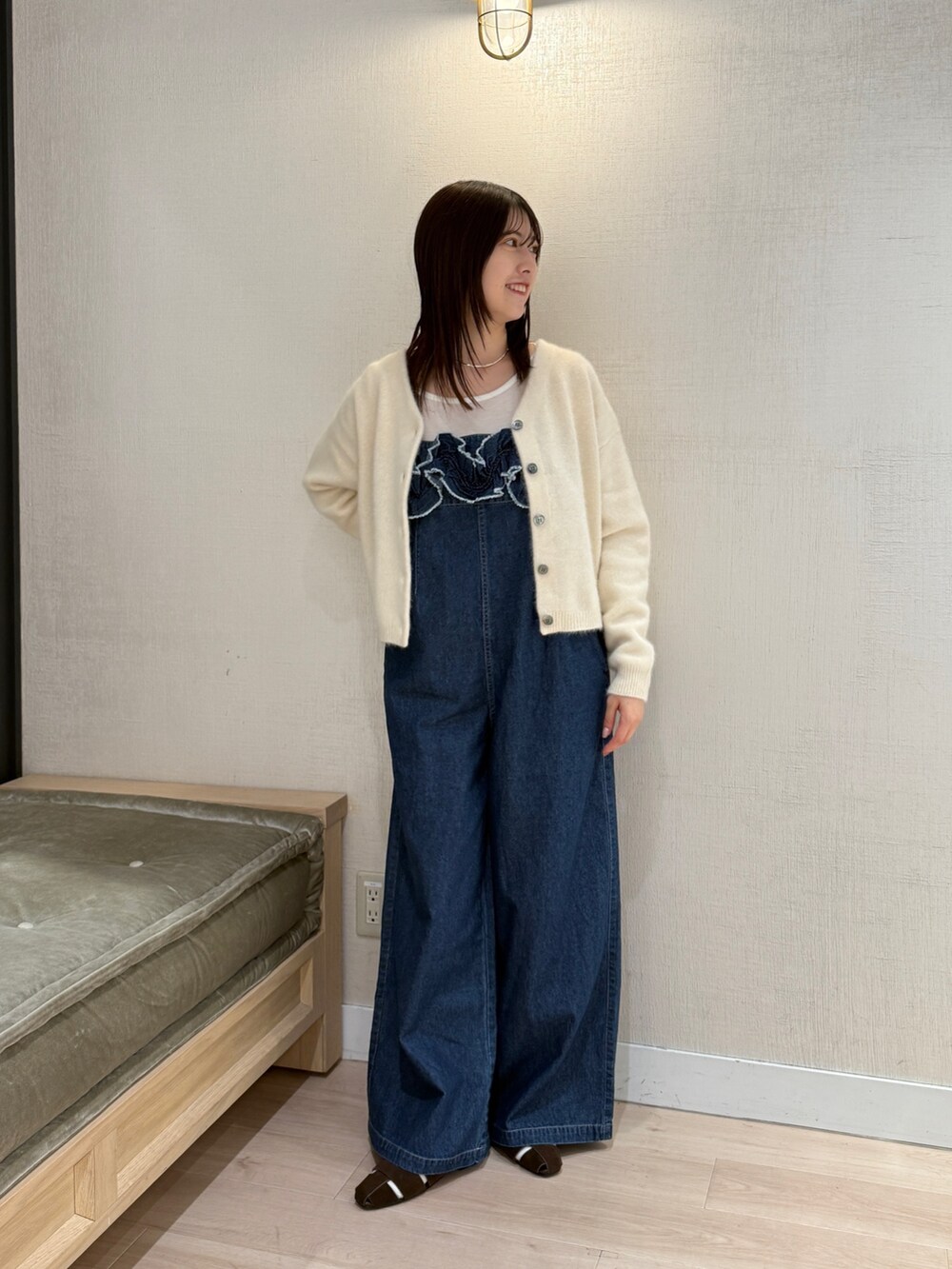 ホワイト系のカーディガン/ボレロ、ブルー系のサロペット/オーバーオール、ブラウン系のパンプスを着用したレディースの秋コーディネートの3枚目の写真