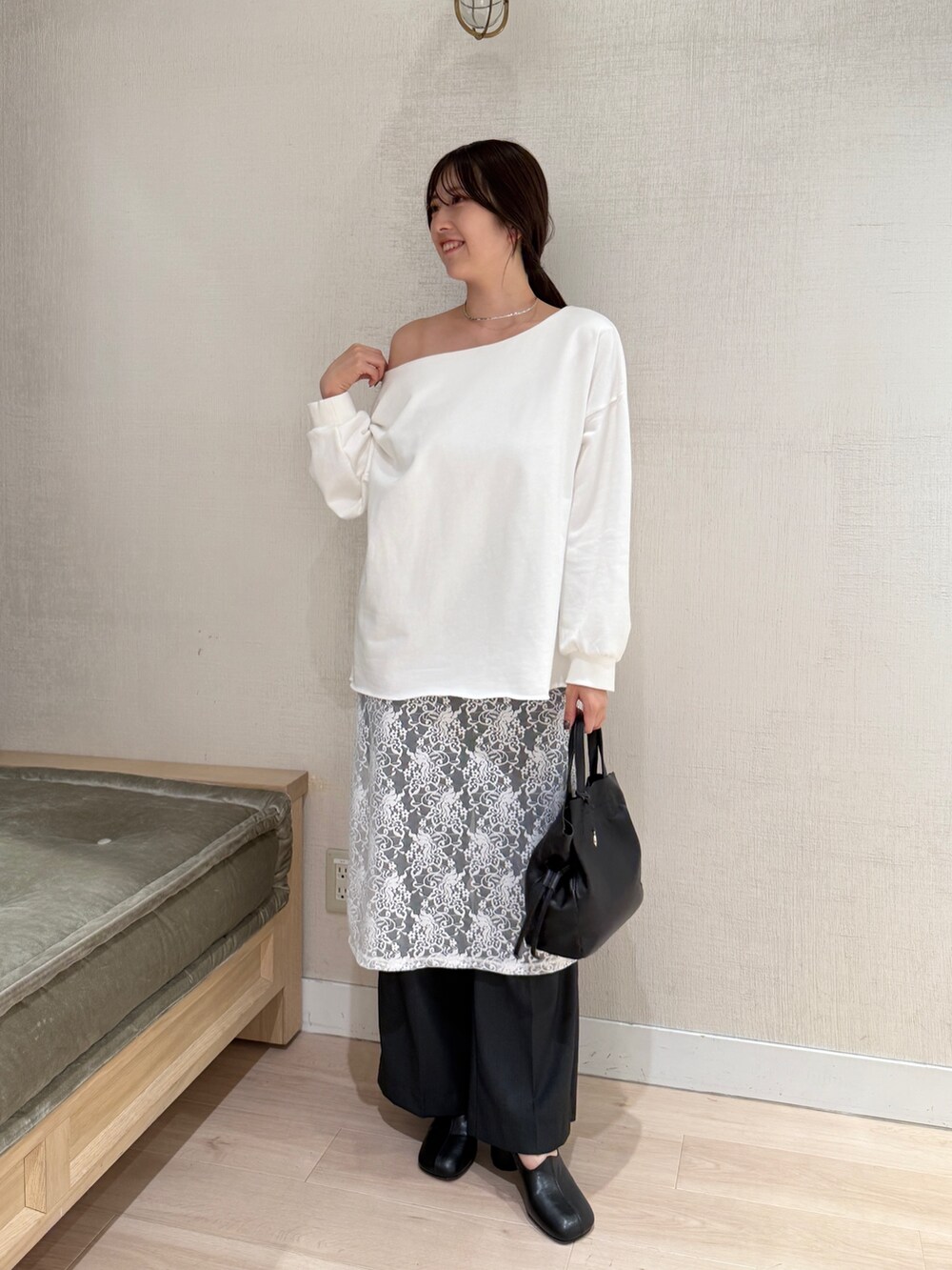 ホワイト系のパーカー、ホワイト系のスカート、グレー系のスラックスを着用したレディースの秋コーディネートの2枚目の写真