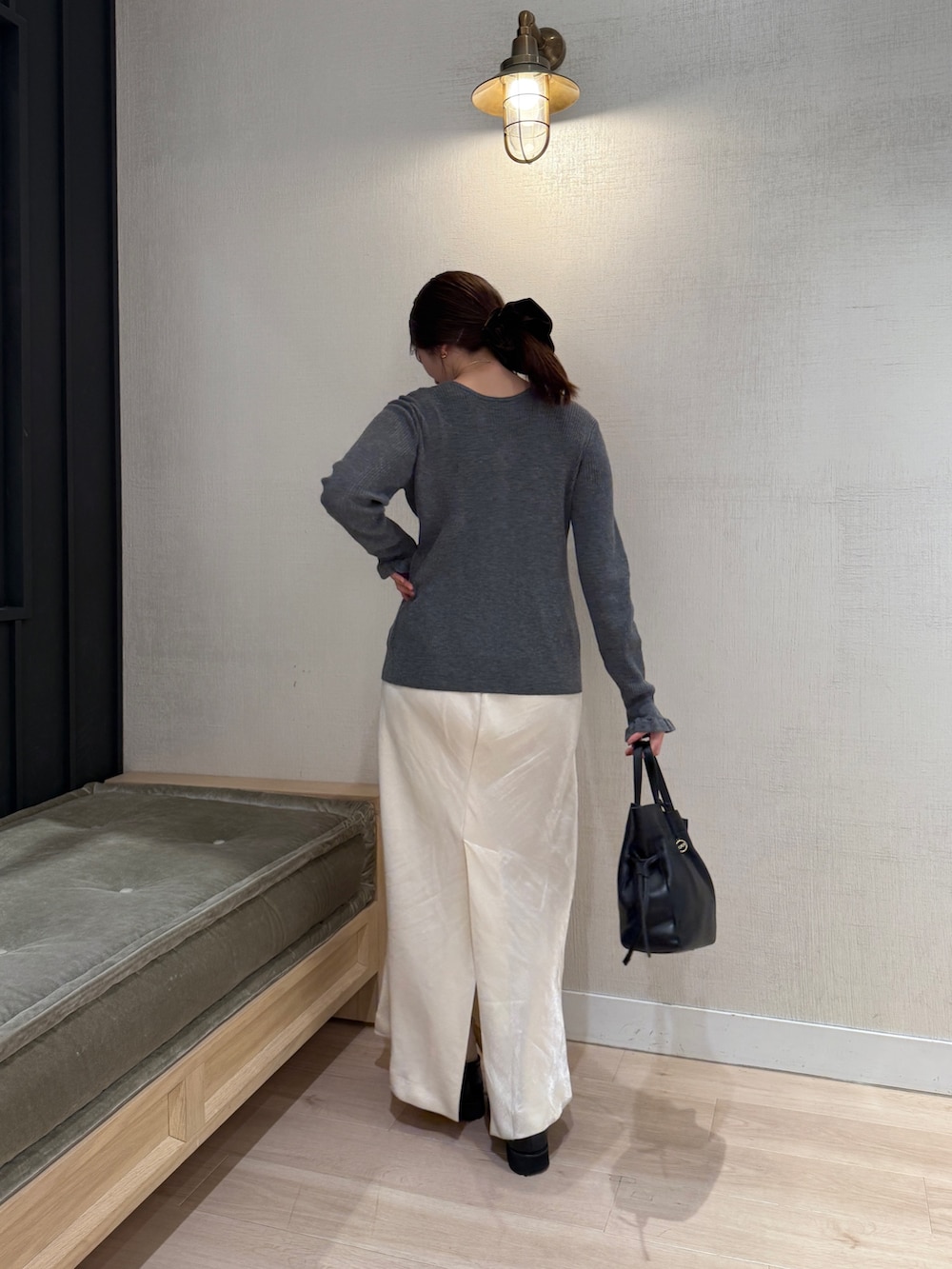 グレー系のカーディガン/ボレロ、ホワイト系のスカート、ブラック系のショルダーバッグを着用したレディースの秋コーディネートの3枚目の写真