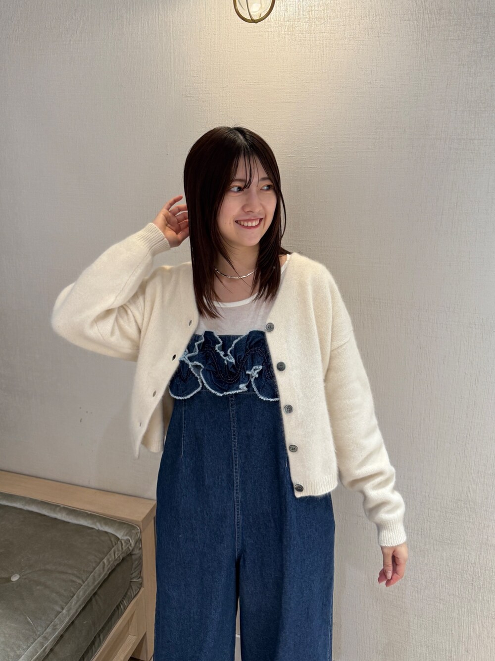 ホワイト系のカーディガン/ボレロ、ブルー系のサロペット/オーバーオール、ブラウン系のパンプスを着用したレディースの秋コーディネートの6枚目の写真