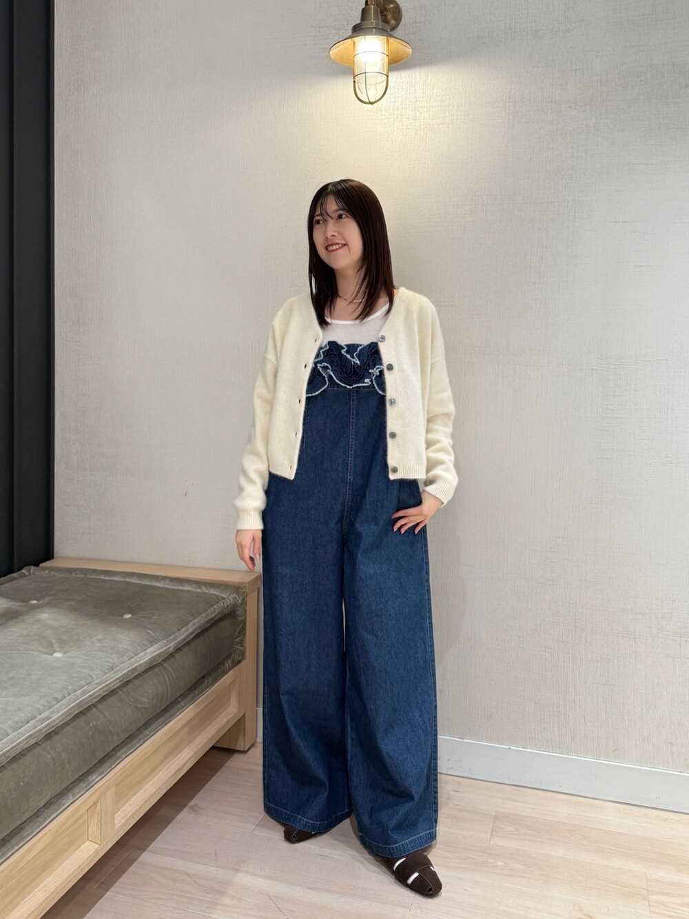 ホワイト系のカーディガン/ボレロ、ブルー系のサロペット/オーバーオール、ブラウン系のパンプスを着用したレディースの秋コーディネートの2枚目の写真