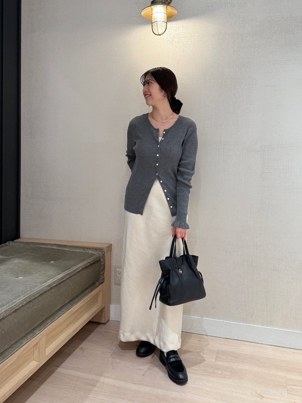 グレー系のカーディガン/ボレロ、ホワイト系のスカート、ブラック系のショルダーバッグを着用したレディースの秋コーディネートの7枚目の写真