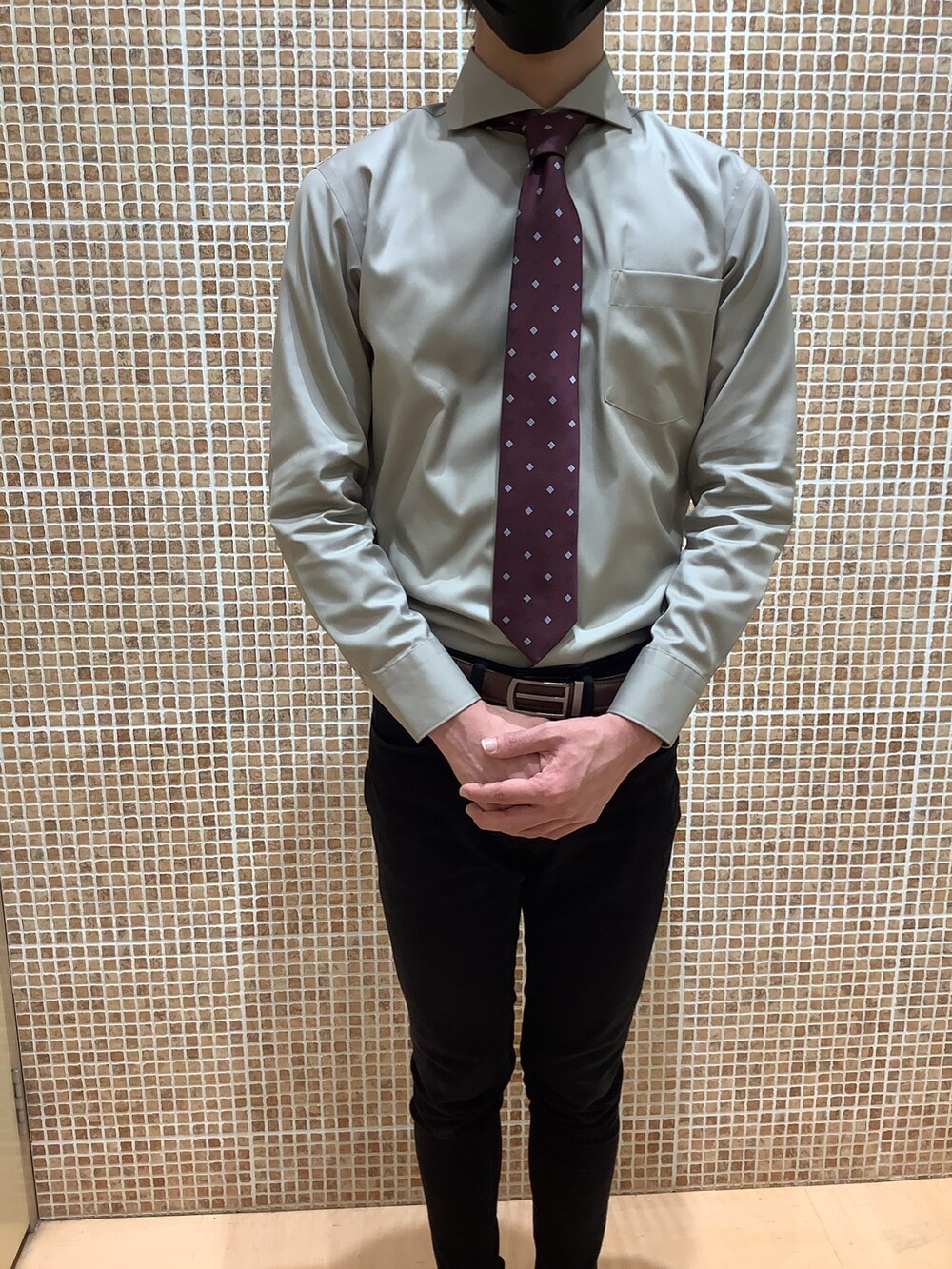 ブラウン系のビジネスシャツ、レッド系のネクタイを着用したメンズの冬コーディネートの2枚目の写真