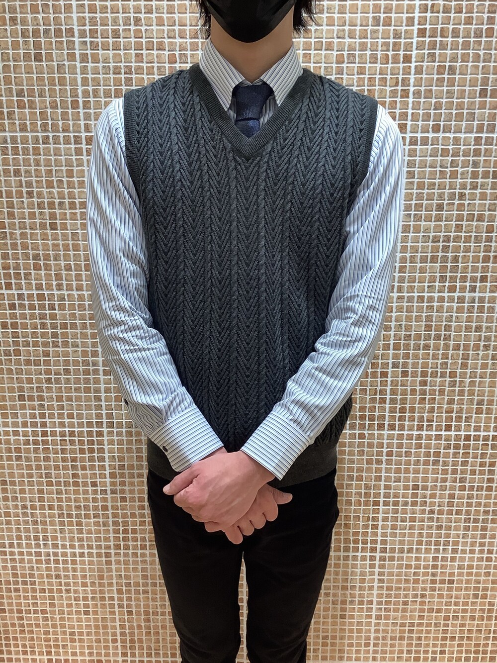 ブルー系のビジネスシャツ、グレー系のベストを着用したレディースの冬コーディネートの2枚目の写真