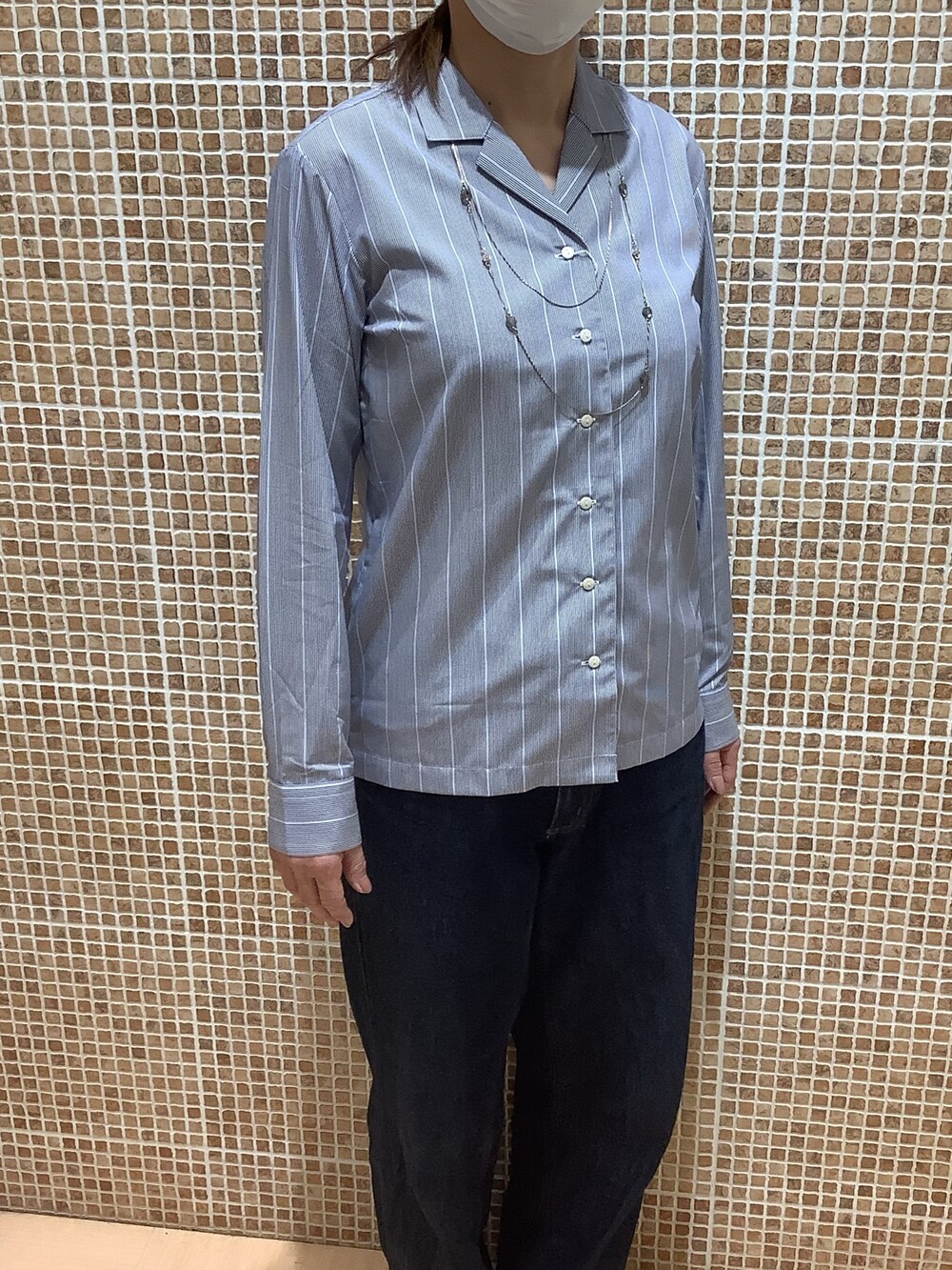 ブルー系のビジネスシャツを着用したレディースの春コーディネートの2枚目の写真