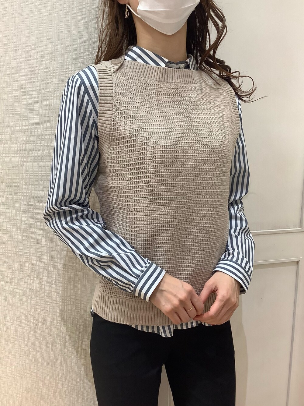 ベージュ系のベスト、ブルー系のシャツ/ブラウスを着用したレディースの春コーディネートの3枚目の写真