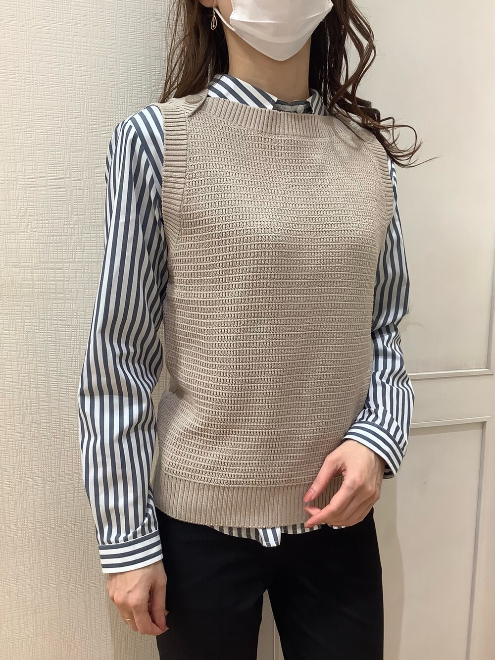 ベージュ系のベスト、ブルー系のシャツ/ブラウスを着用したレディースの春コーディネートの2枚目の写真