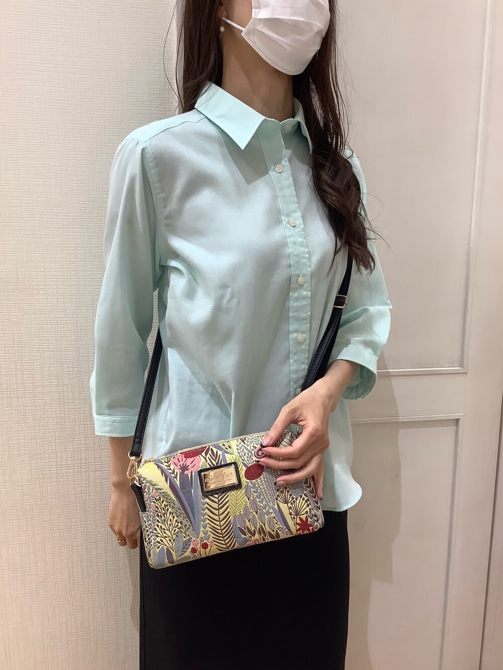 グリーン系のシャツ/ブラウス、ベージュ系のポーチを着用したレディースの夏コーディネートの3枚目の写真