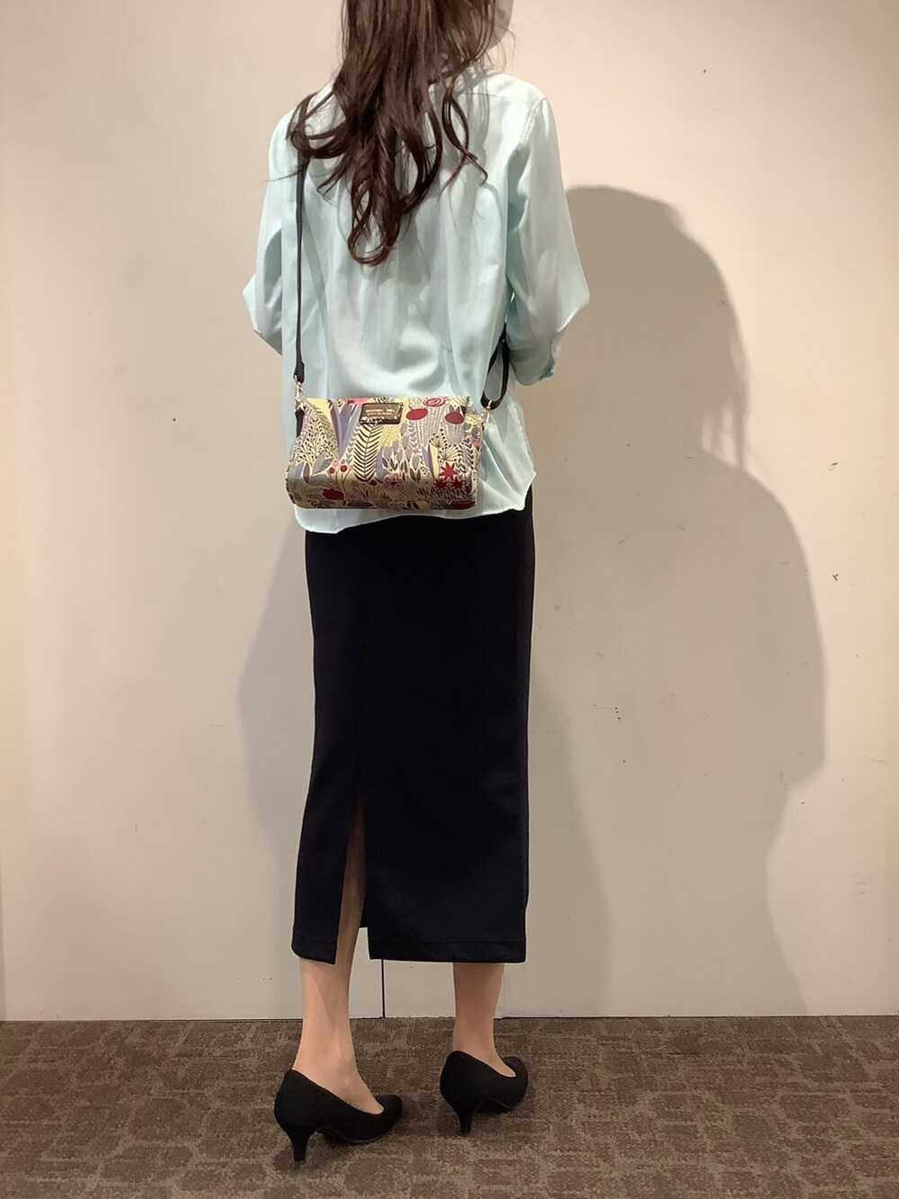 グリーン系のシャツ/ブラウス、ベージュ系のポーチを着用したレディースの夏コーディネートの2枚目の写真