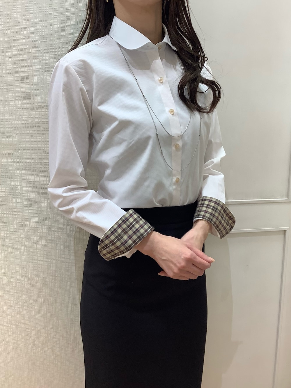 オレンジ系のビジネスシャツを着用したレディースの冬コーディネートの2枚目の写真