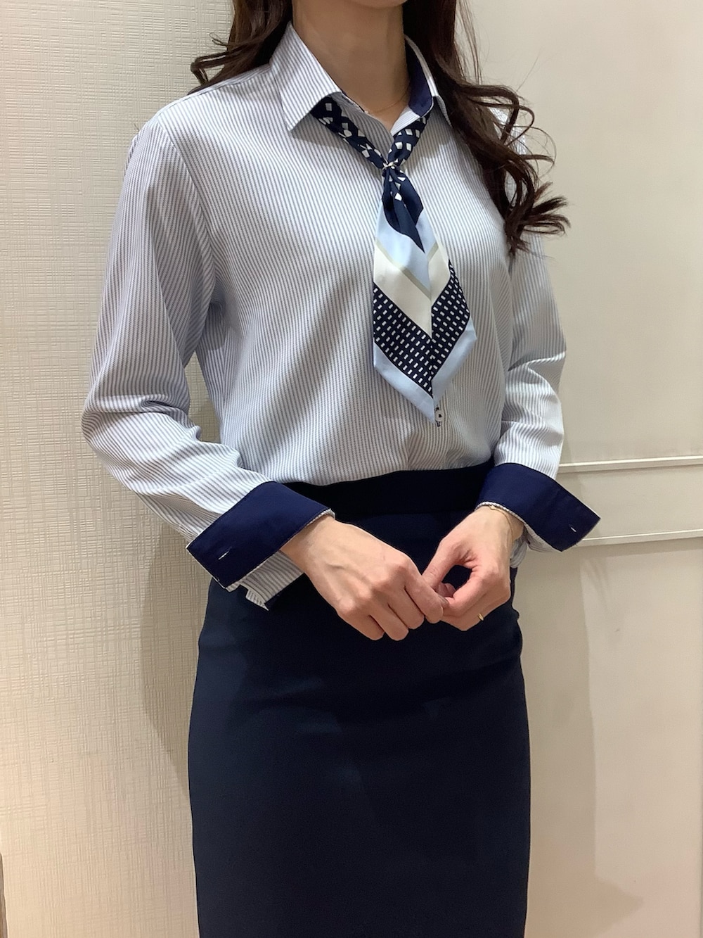 ブルー系のビジネスシャツ、ブルー系のバンダナ/スカーフを着用したレディースの春コーディネートの2枚目の写真