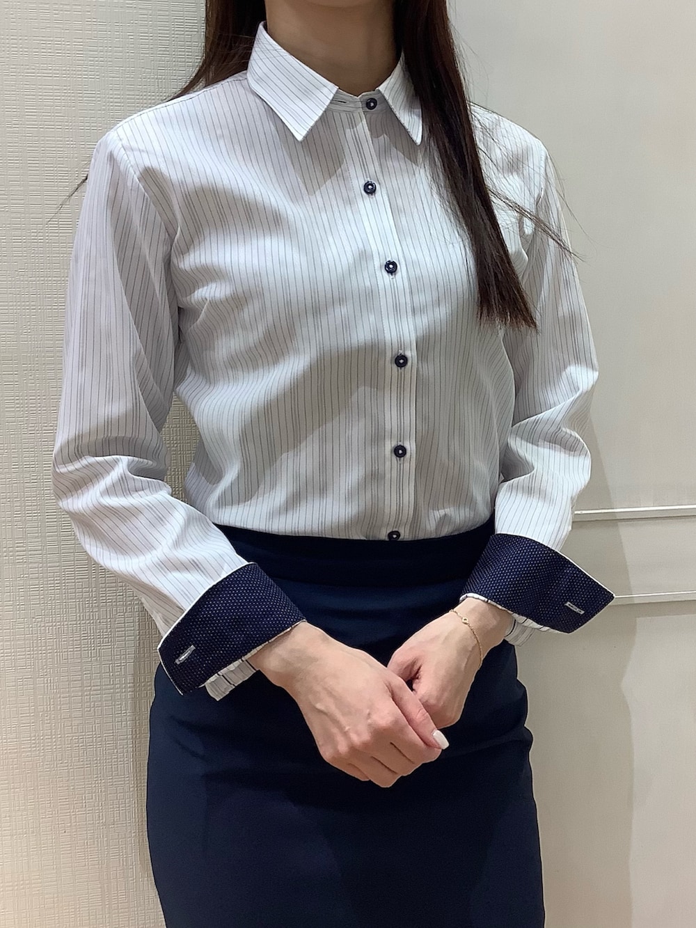 ブルー系のビジネスシャツを着用したレディースの春コーディネートの2枚目の写真