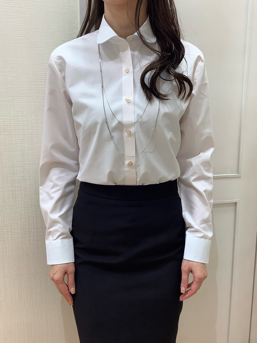 オレンジ系のビジネスシャツを着用したレディースの冬コーディネートの3枚目の写真