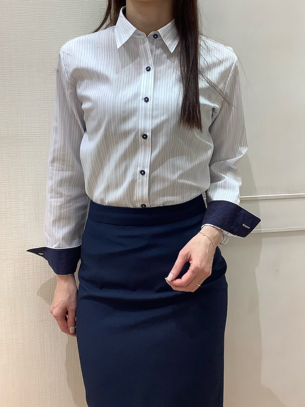 ブルー系のビジネスシャツを着用したレディースの春コーディネートの3枚目の写真