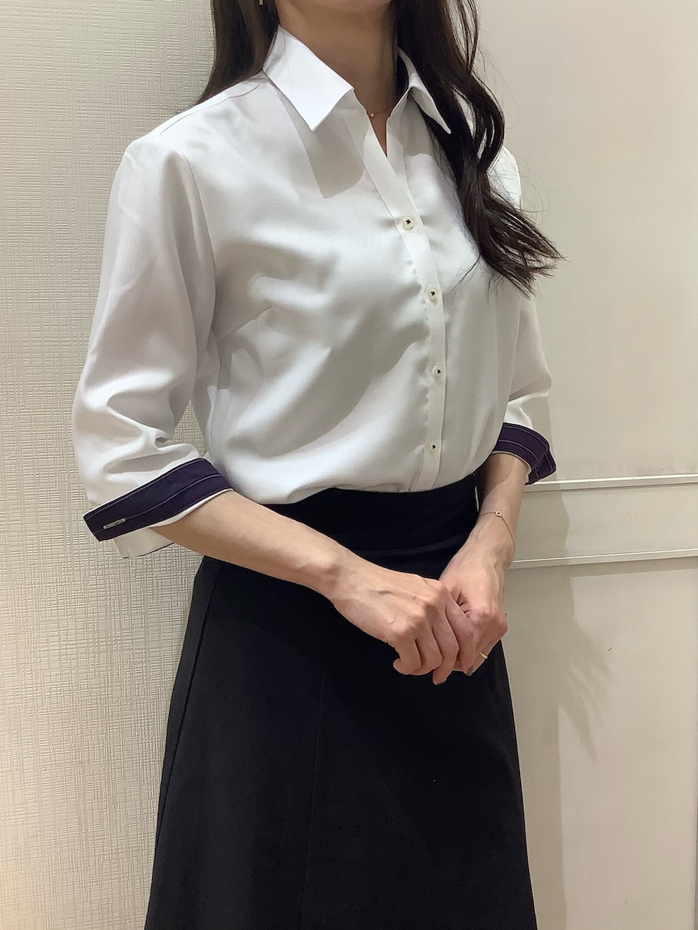 ホワイト系のビジネスシャツを着用したレディースの夏コーディネートの2枚目の写真