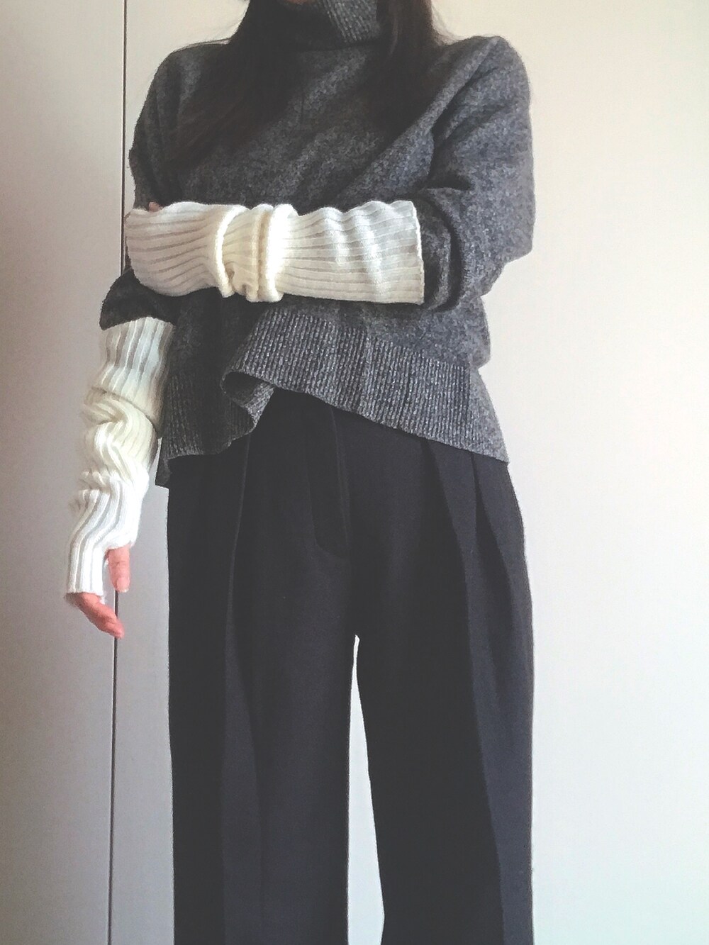 グレー系のニット/セーター、ブラック系のパンツ、ホワイト系の手袋を着用したレディースの秋コーディネートの2枚目の写真