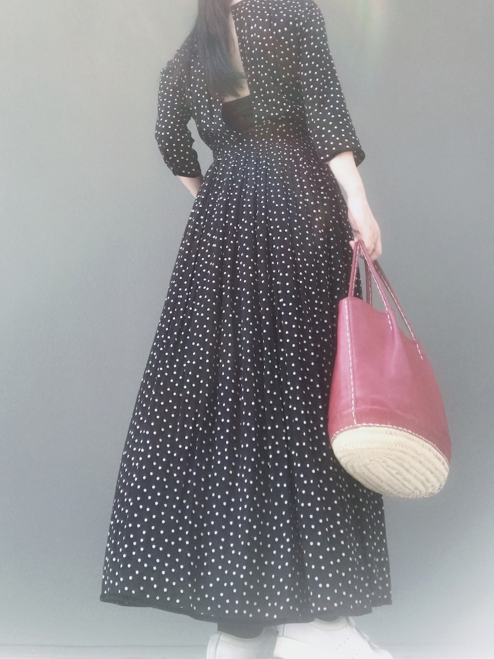 ホワイト系のスニーカー、レッド系のバッグ、ブラック系のワンピースを着用したレディースの春コーディネートの2枚目の写真